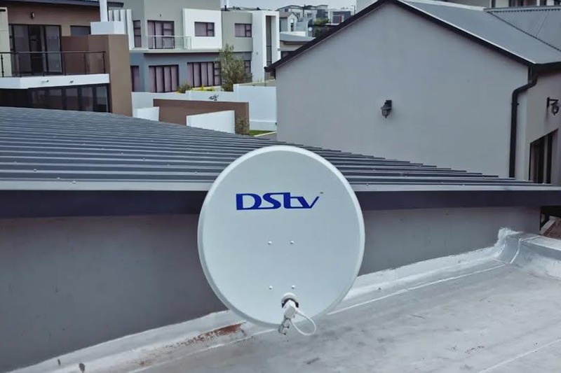 DSTV installer mounting a satellite dish at sunset in Pretoria